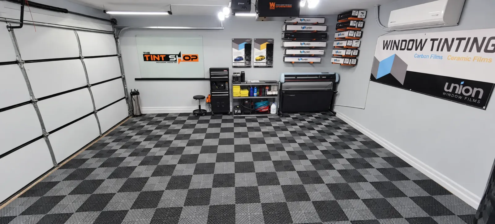 The back wall of the workspace: their logo glass, Union film boxes on the racks and the film plotter