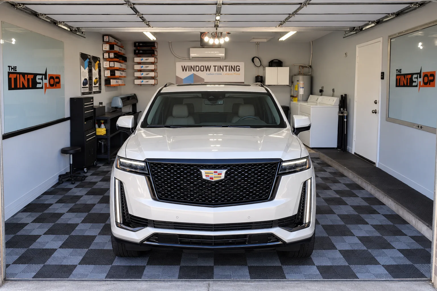 A white Cadillac Escalade with tinted windows, ready to go home from The Tint Shop’s workspace